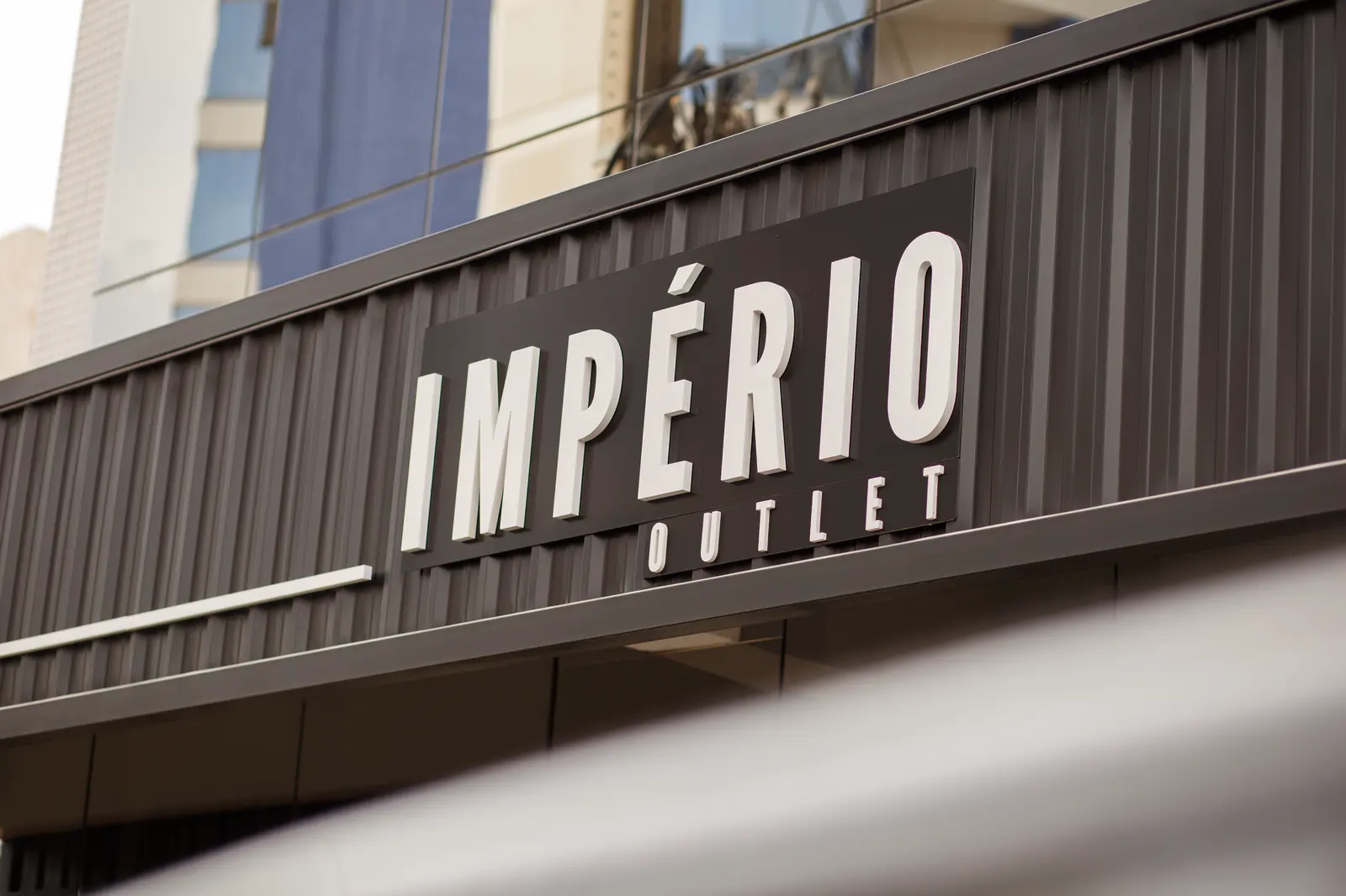Fachada da loja Império Outlet com letreiro em metal escuro